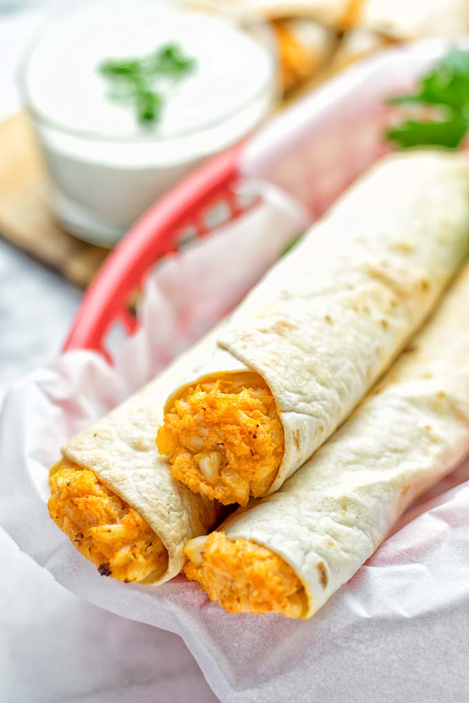 These Buffalo Cauliflower Taquitos are the ultimate comfort food. Vegan, gluten free, super easy to make and insanely delicious. An amazing dairy free alternative for dinner, lunch, potluck, party, meal prep, work lunch option. Once you'll try these, they will go into your daily rotation. #vegan #glutenfree #vegetarian #dairyfree #plantbased #contentednesscooking #lunch #dinner #mealprep #worklunchideas #taquitos #buffalocauliflower #easyfood #budgetfriendly #makeahedmeals #cauliflower