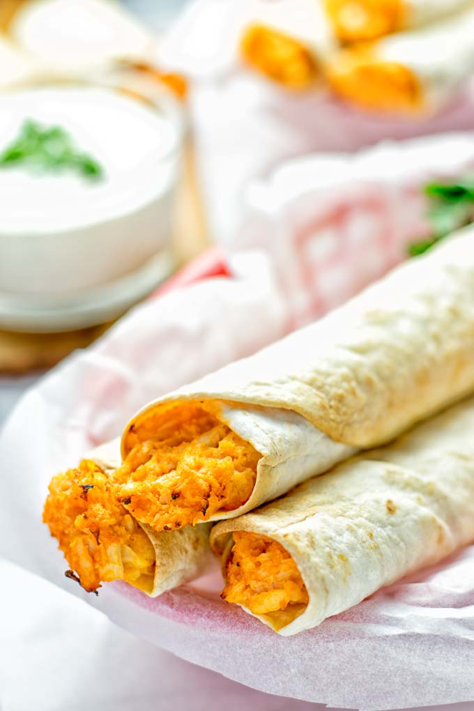 These Buffalo Cauliflower Taquitos are the ultimate comfort food. Vegan, gluten free, super easy to make and insanely delicious. An amazing dairy free alternative for dinner, lunch, potluck, party, meal prep, work lunch option. Once you'll try these, they will go into your daily rotation. #vegan #glutenfree #vegetarian #dairyfree #plantbased #contentednesscooking #lunch #dinner #mealprep #worklunchideas #taquitos #buffalocauliflower #easyfood #budgetfriendly #makeahedmeals #cauliflower