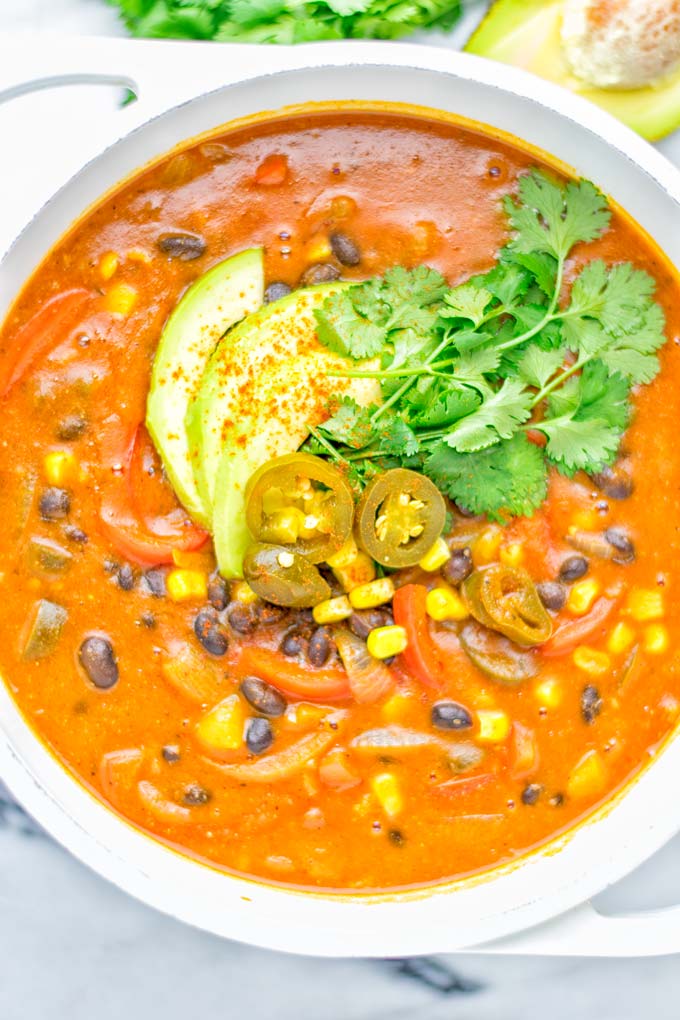 This Spicy Garlic Enchilada Soup is made in one pot, insanely delicious and super easy to make. Naturally vegan, gluten free and amazing for dinner, lunch, meal prep and work lunch. Try it now you won't believe how easy it is! #vegan #glutenfree #dairyfree # vegetarian #enchilada #soup #dinner #lunch #mealprep #worklunchideas #onepotmeals #enchiladasoup #contentednesscooking
