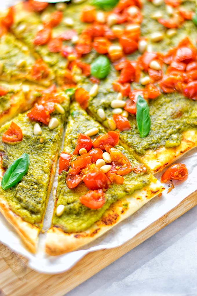 This White Bean and Pesto Pizza is super easy to make, entirely vegan and gluten free. If you love pizza and pesto you're coming to the right place. It's so delicious for lunch, dinner, meal preparation, and work lunch. Try it now and fall in love. #vegan #glutenfree #dairyfree #contentednesscooking #pesto #pizza #mealprep #worklunchideas #easyfood #lunch #dinner