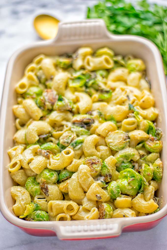 This Garlic Brussels Sprouts Mac and Cheese is entirely vegan, gluten free, and super easy to make. It's an amazing comfort food for dinner, lunch, meal prep, work lunches, date nights and of course the holidays. Everyone will get addicted to this from the first to the last bite, try it now! #vegan #glutenfree #dairyfree #vegetarian #mealprep #dinner #lunch #worklunchideas #holidays #macandcheese #contentednesscooking #pasta #thanksgiving