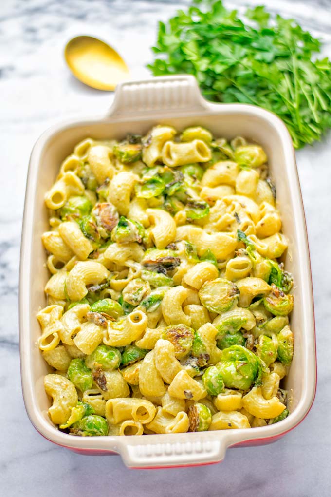 This Garlic Brussels Sprouts Mac and Cheese is entirely vegan, gluten free, and super easy to make. It's an amazing comfort food for dinner, lunch, meal prep, work lunches, date nights and of course the holidays. Everyone will get addicted to this from the first to the last bite, try it now! #vegan #glutenfree #dairyfree #vegetarian #mealprep #dinner #lunch #worklunchideas #holidays #macandcheese #contentednesscooking #pasta #thanksgiving