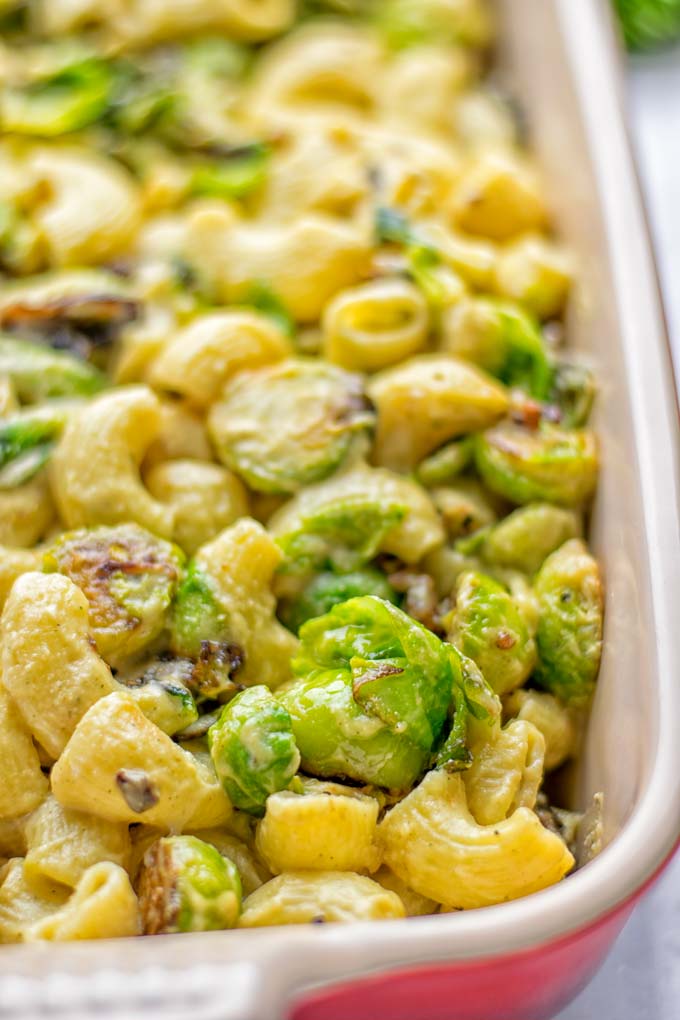 This Garlic Brussels Sprouts Mac and Cheese is entirely vegan, gluten free, and super easy to make. It's an amazing comfort food for dinner, lunch, meal prep, work lunches, date nights and of course the holidays. Everyone will get addicted to this from the first to the last bite, try it now! #vegan #glutenfree #dairyfree #vegetarian #mealprep #dinner #lunch #worklunchideas #holidays #macandcheese #contentednesscooking #pasta #thanksgiving