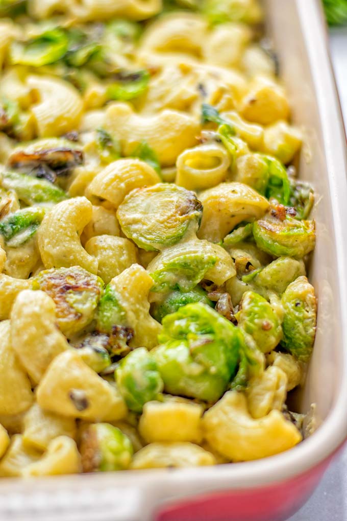 This Garlic Brussels Sprouts Mac and Cheese is entirely vegan, gluten free, and super easy to make. It's an amazing comfort food for dinner, lunch, meal prep, work lunches, date nights and of course the holidays. Everyone will get addicted to this from the first to the last bite, try it now! #vegan #glutenfree #dairyfree #vegetarian #mealprep #dinner #lunch #worklunchideas #holidays #macandcheese #contentednesscooking #pasta #thanksgiving
