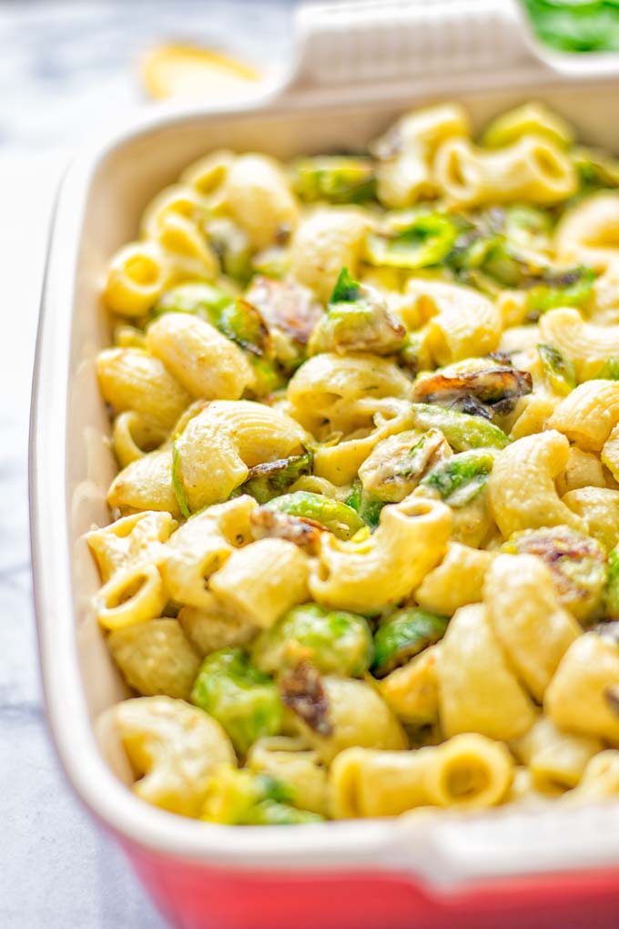 This Garlic Brussels Sprouts Mac and Cheese is entirely vegan, gluten free, and super easy to make. It's an amazing comfort food for dinner, lunch, meal prep, work lunches, date nights and of course the holidays. Everyone will get addicted to this from the first to the last bite, try it now! #vegan #glutenfree #dairyfree #vegetarian #mealprep #dinner #lunch #worklunchideas #holidays #macandcheese #contentednesscooking #pasta #thanksgiving
