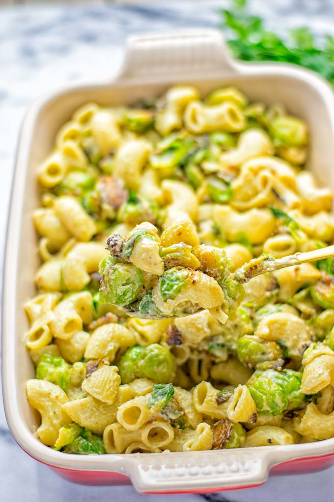 This Garlic Brussels Sprouts Mac and Cheese is entirely vegan, gluten free, and super easy to make. It's an amazing comfort food for dinner, lunch, meal prep, work lunches, date nights and of course the holidays. Everyone will get addicted to this from the first to the last bite, try it now! #vegan #glutenfree #dairyfree #vegetarian #mealprep #dinner #lunch #worklunchideas #holidays #macandcheese #contentednesscooking #pasta #thanksgiving