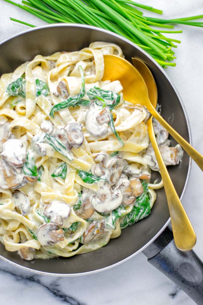 Super creamy and easy to make: Spinach Mushroom Fettuccine Alfredo entirely vegan, gluten free and the ultimate comfort food for dinner, lunch, meal preparation that the whole family will love. If you're looking for a delicious fettuccine Alfredo recipe try it now, it's a keeper. #vegan #glutenfree #dairyfree #vegetarian #contentednesscooking #dinner #lunch #mealprep #worklunchideas #fettuccinealfredo #spinachrecipes #mushroomrecipes #familydinnerideas #fettuccinerecipes #easy20minutemeals