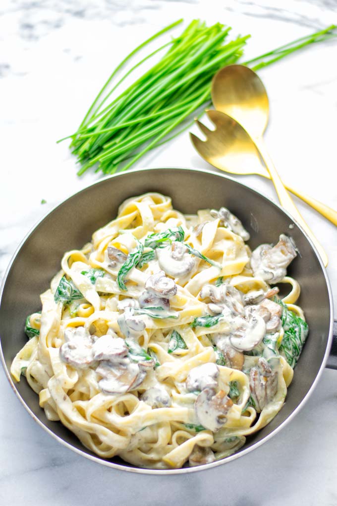 Super creamy and easy to make: Spinach Mushroom Fettuccine Alfredo entirely vegan, gluten free and the ultimate comfort food for dinner, lunch, meal preparation that the whole family will love. If you're looking for a delicious fettuccine Alfredo recipe try it now, it's a keeper. #vegan #glutenfree #dairyfree #vegetarian #contentednesscooking #dinner #lunch #mealprep #worklunchideas #fettuccinealfredo #spinachrecipes #mushroomrecipes #familydinnerideas #fettuccinerecipes #easy20minutemeals