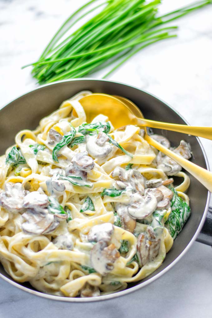 Super creamy and easy to make: Spinach Mushroom Fettuccine Alfredo entirely vegan, gluten free and the ultimate comfort food for dinner, lunch, meal preparation that the whole family will love. If you're looking for a delicious fettuccine Alfredo recipe try it now, it's a keeper. #vegan #glutenfree #dairyfree #vegetarian #contentednesscooking #dinner #lunch #mealprep #worklunchideas #fettuccinealfredo #spinachrecipes #mushroomrecipes #familydinnerideas #fettuccinerecipes #easy20minutemeals