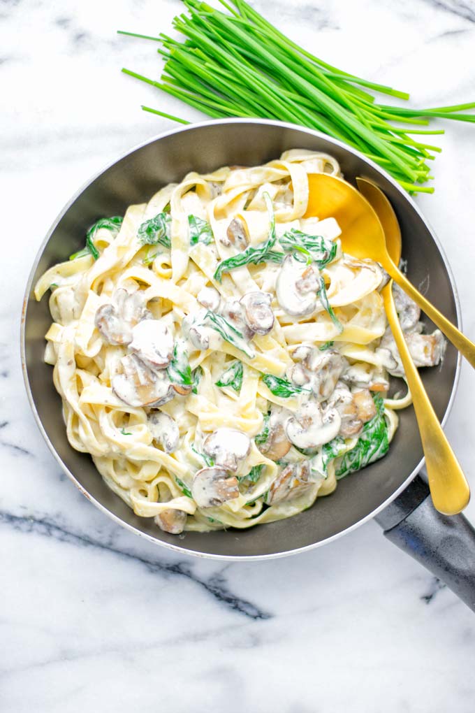 Super creamy and easy to make: Spinach Mushroom Fettuccine Alfredo entirely vegan, gluten free and the ultimate comfort food for dinner, lunch, meal preparation that the whole family will love. If you're looking for a delicious fettuccine Alfredo recipe try it now, it's a keeper. #vegan #glutenfree #dairyfree #vegetarian #contentednesscooking #dinner #lunch #mealprep #worklunchideas #fettuccinealfredo #spinachrecipes #mushroomrecipes #familydinnerideas #fettuccinerecipes #easy20minutemeals