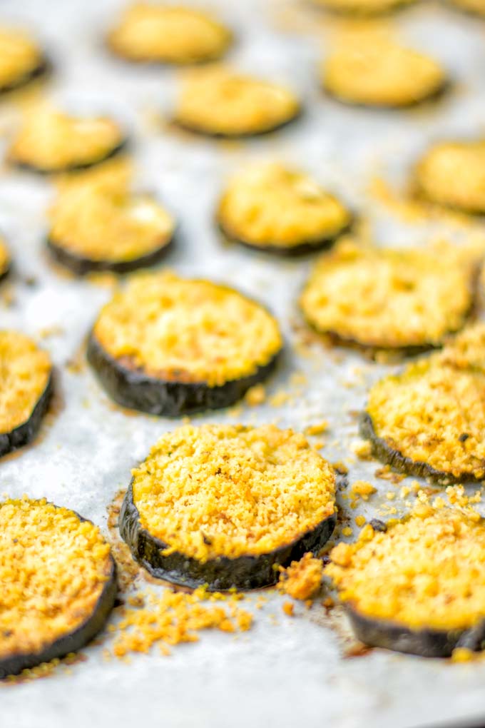 This Baked Zucchini Parmesan is entirely vegan, gluten free and will be a family favorite. Serve it with pasta, dips, as appetizer, dinner, lunches, meal preparation, or work lunch. Sprinkled with the best dairy free parmesan cheese that makes all the difference. Try it now. #vegan #dairyfree #vegetarian #contentednesscooking #dinner #lunch #mealprep #worklunchideas #zucchiniparmesan #zucchiniparmesanbaked #zucchiniparmesancrisps #comfortfood #kidfriendlydinners #familydinnerideas