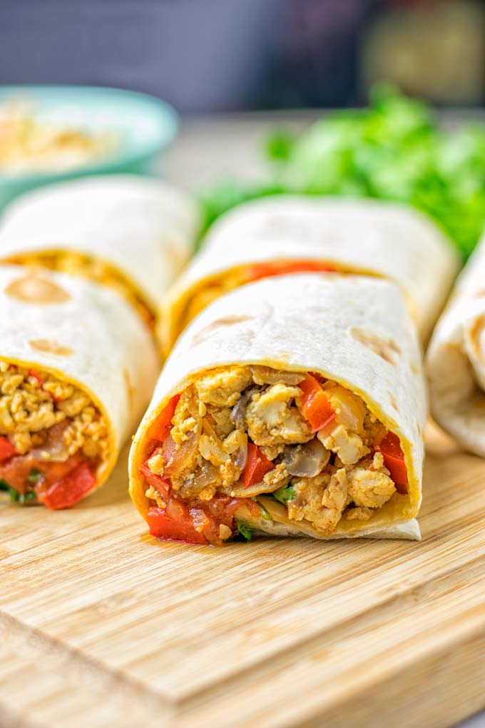 This Vegan Breakfast Burrito with Tofu Scramble is super easy to make and seriously the best burritos you've ever made and tasted. No one would guess it's entirely vegan, gluten free and your family won't miss the cheese or meat in these. These are also an amazing pick for meal prep, dinner, lunch, work lunch and so much more. #vegan #dairyfree #glutenfree #contentednesscooking #breakfastburritos #tofuscramble #breakfastideas #budgetmeals #dinner #lunch #mealprep #worklunchideas