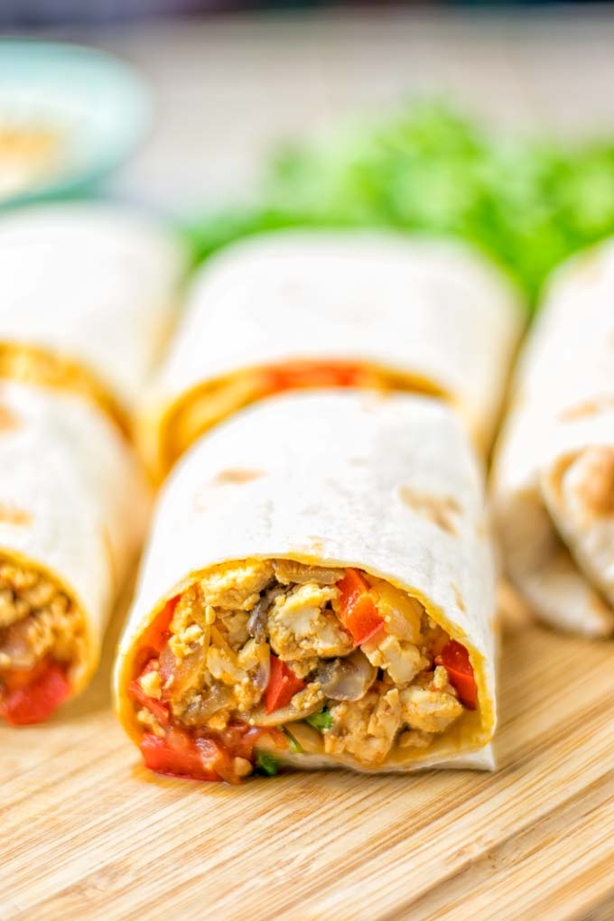 This Vegan Breakfast Burrito with Tofu Scramble is super easy to make and seriously the best burritos you've ever made and tasted. No one would guess it's entirely vegan, gluten free and your family won't miss the cheese or meat in these. These are also an amazing pick for meal prep, dinner, lunch, work lunch and so much more. #vegan #dairyfree #glutenfree #contentednesscooking #breakfastburritos #tofuscramble #breakfastideas #budgetmeals #dinner #lunch #mealprep #worklunchideas