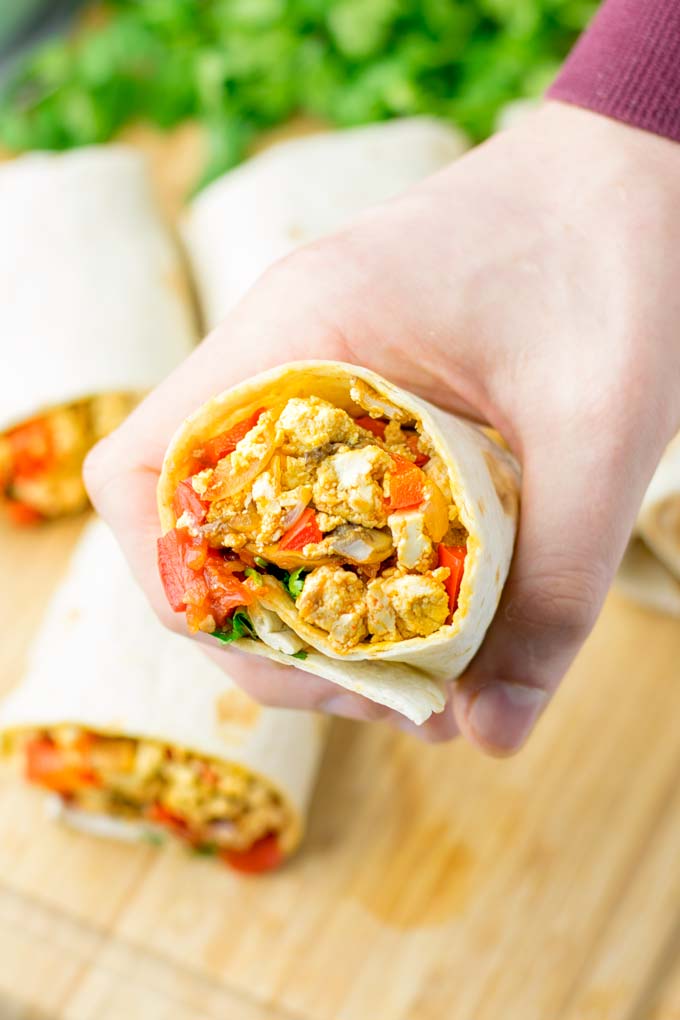 This Vegan Breakfast Burrito with Tofu Scramble is super easy to make and seriously the best burritos you've ever made and tasted. No one would guess it's entirely vegan, gluten free and your family won't miss the cheese or meat in these. These are also an amazing pick for meal prep, dinner, lunch, work lunch and so much more. #vegan #dairyfree #glutenfree #contentednesscooking #breakfastburritos #tofuscramble #breakfastideas #budgetmeals #dinner #lunch #mealprep #worklunchideas