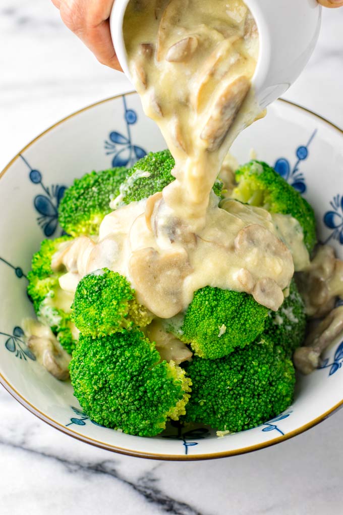 Mushroom Gravy is poured over a bowl of steamed broccoli.