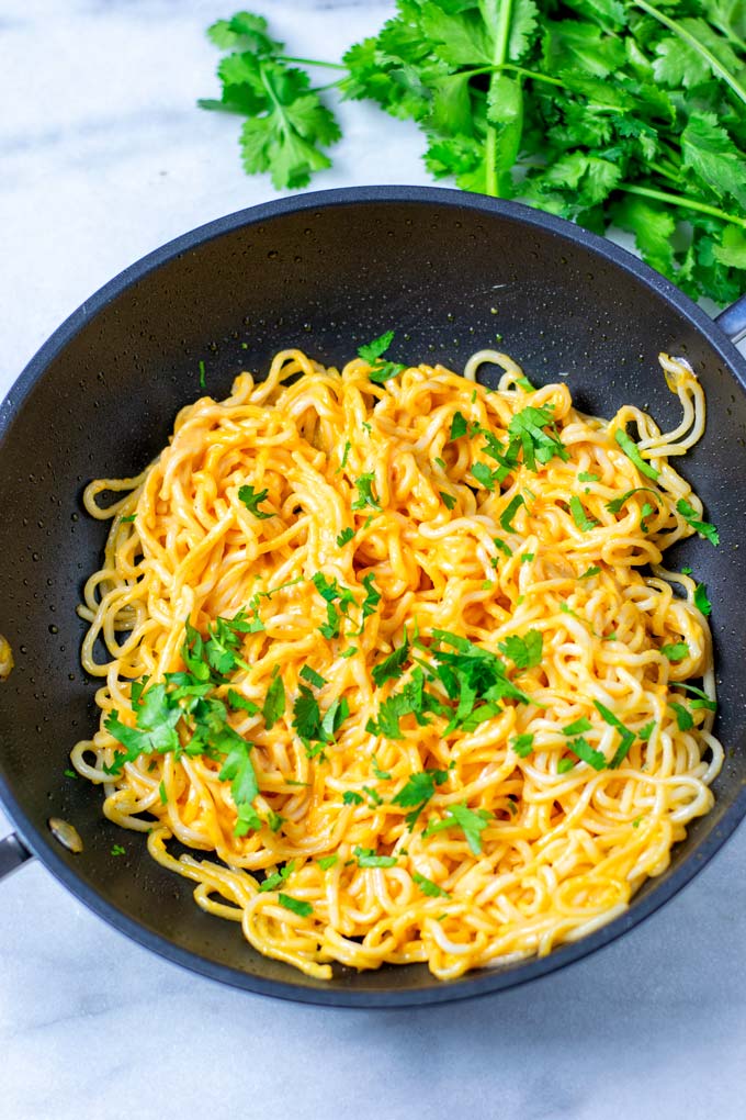 Pasta in a sauce pan garnished with parsley.
