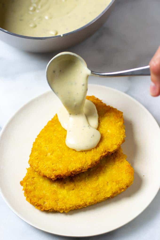 Country Gravy is poured over a stack of vegan chicken steaks.