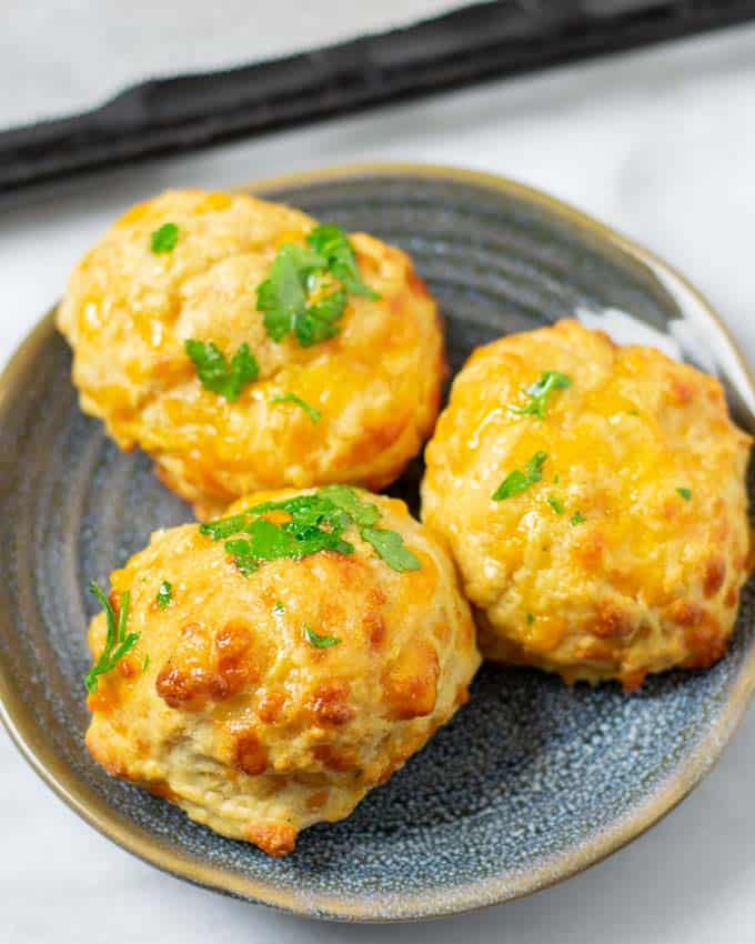 Three Cheddar Bay Biscuits on a blue plate.
