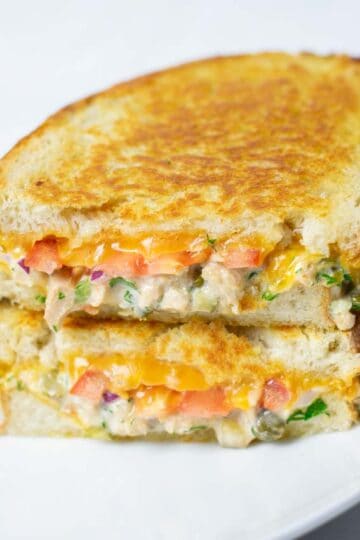 View of a stack of cut open Tuna Melt sandwiches.