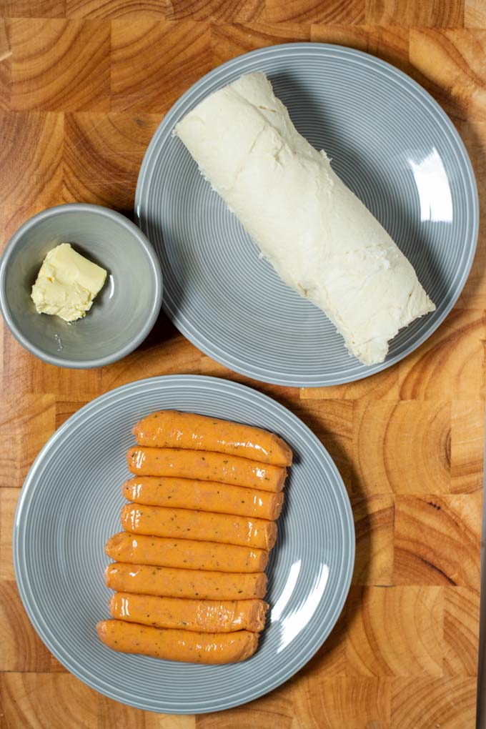 Ingredients needed for making Pigs in a Blanket are collected on a board.