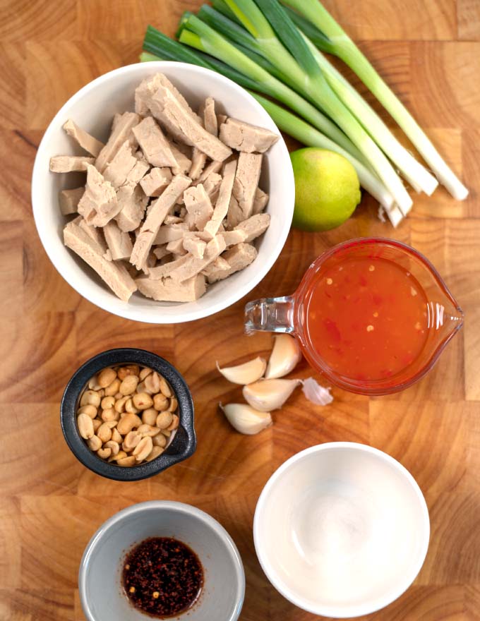 Ingredients needed to make Thai Chicken collected on a board.