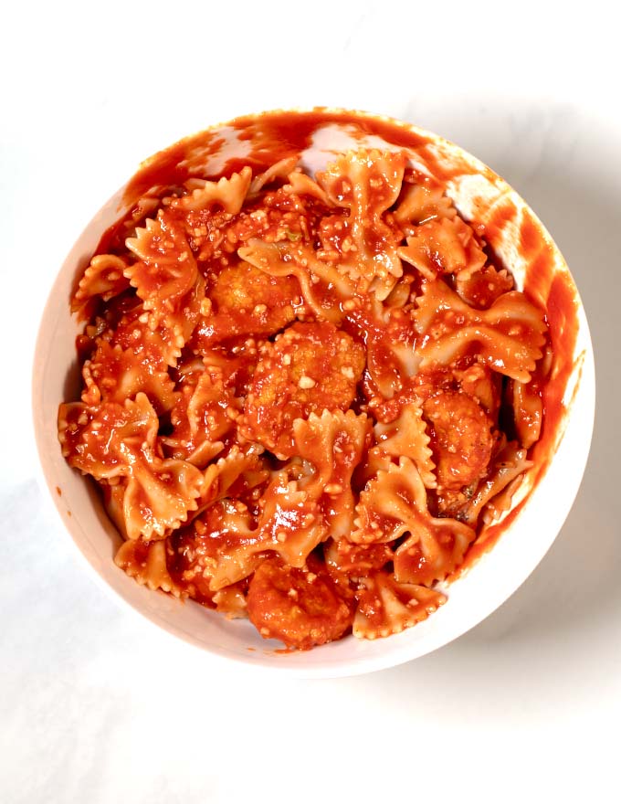 Mixed bow tie pasta, marinara, cheese, and chicken nuggets.