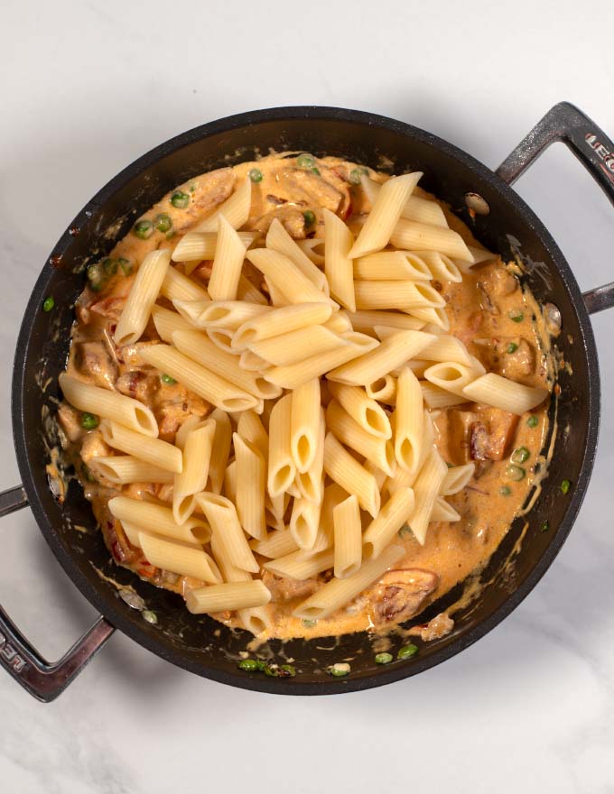 Pasta is added to sauce.