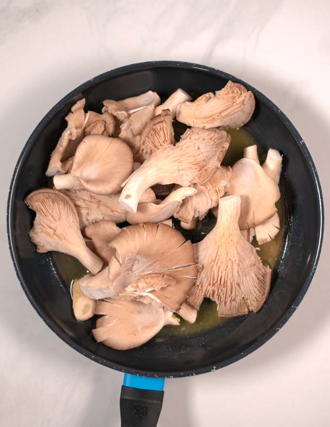 Oyster Mushrooms are fried in a pan with vegan butter and olive oil.