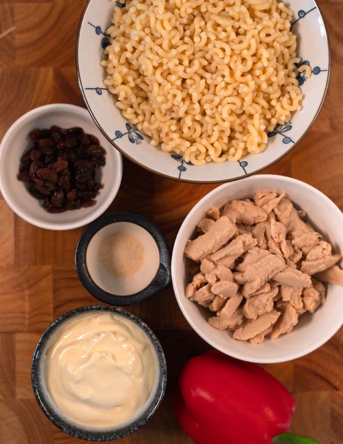 Ingredients for making Chicken Macaroni collected on a board.