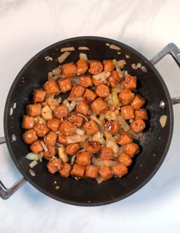 Showing sauteed onions and cut hot dogs.