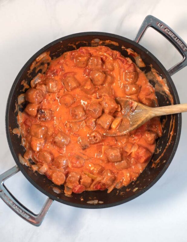 View of a pan with creamy Hot Dog Pasta sauce.