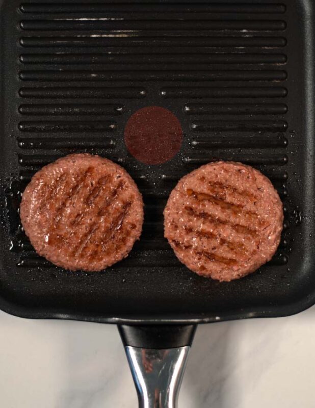 Vegan burger patties in a grilling pan.