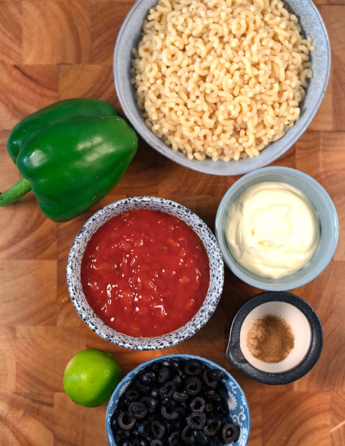 Ingredients needed to make Mexican Macaroni Salad are collected on a board.