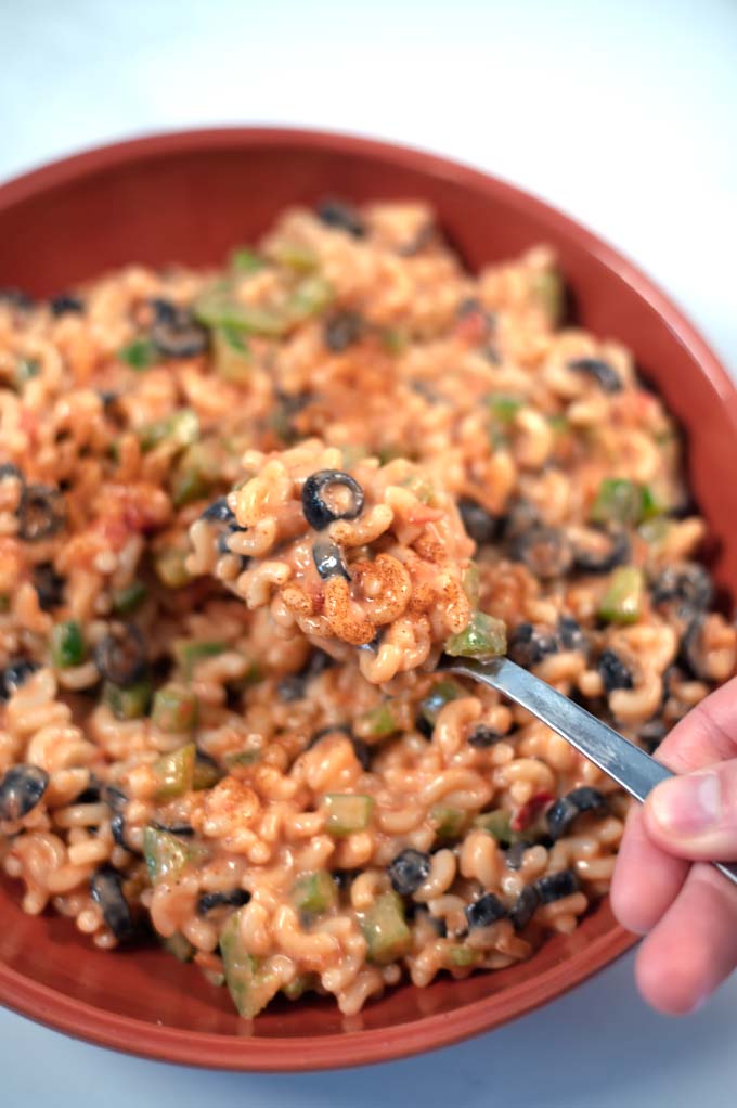 A large spoon is lifted ftom the mixing bowl.