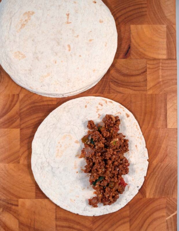 Showing the filling of a tortilla.