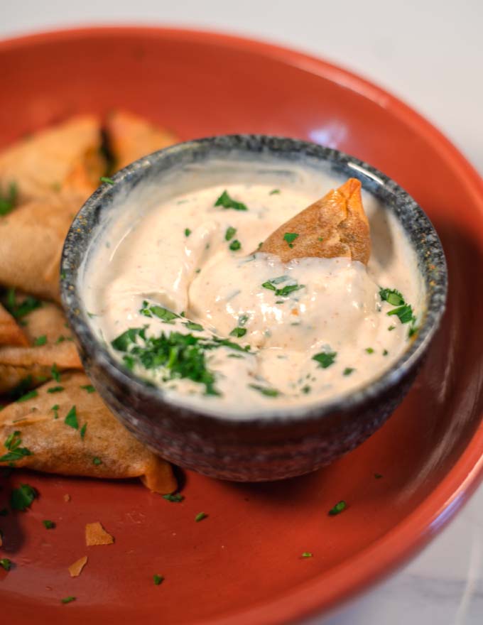 Samosa in a bowl with samosa sauce.