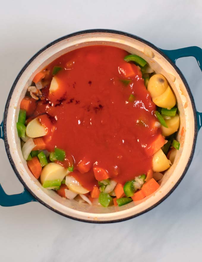 Tomato sauce and vegetable broth are given to the vegetable mixture.