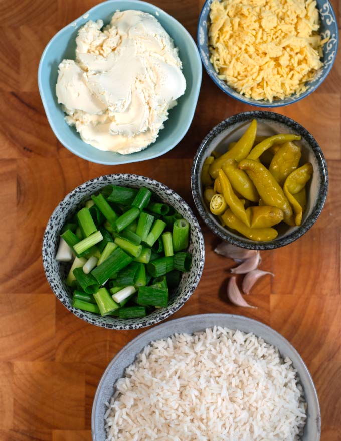 Ingredients needed to make Chile Rice Casserole are collected on a wooden board.