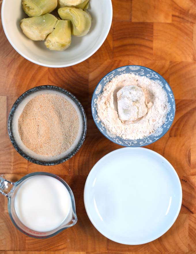 Artichoke hearts are dredged in flour after having been dipped in milk.