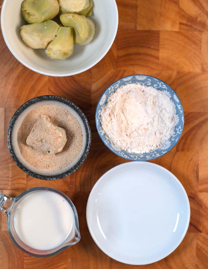 Floured artichoke hearts are dredged in breadcrumbs.
