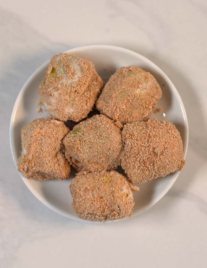 A plate with fully breaded artichoke hearts.