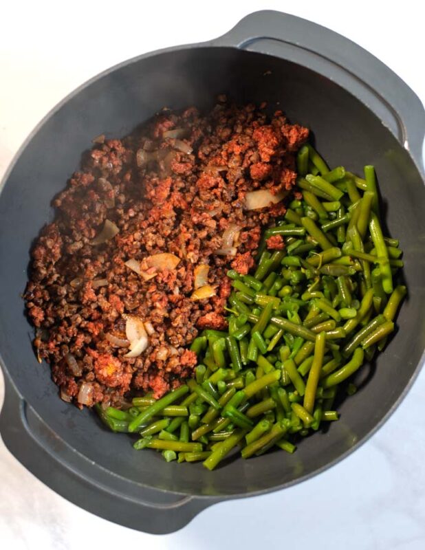 A large mixing bowl with the green beans and hamburger meat filling.