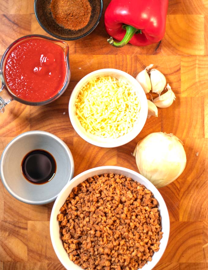 Ingredients needed to make Keto Sloppy Joe Casserole collected on a wooden board.