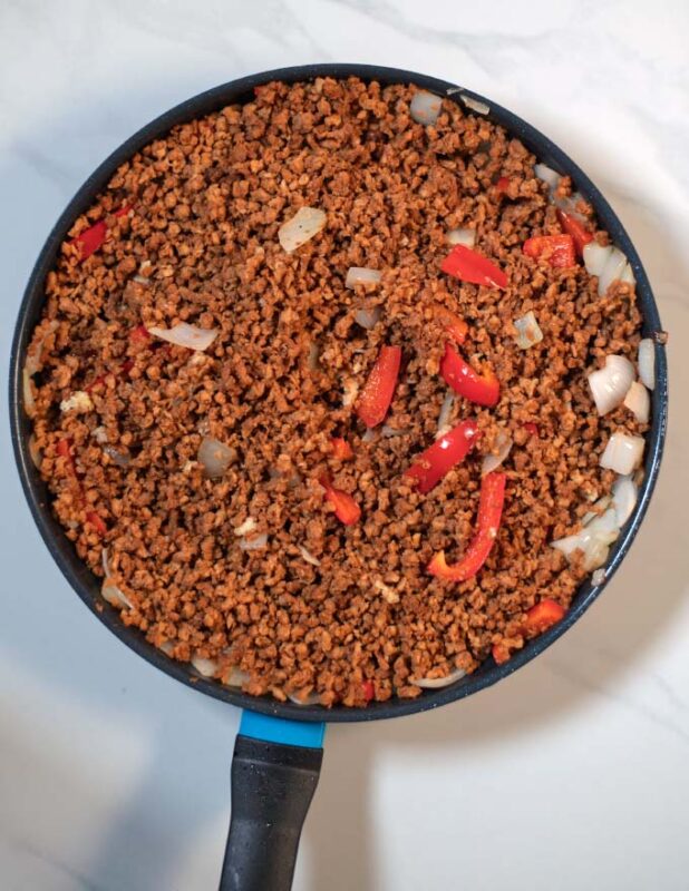 Vegan hamburger meat is added to the pan.