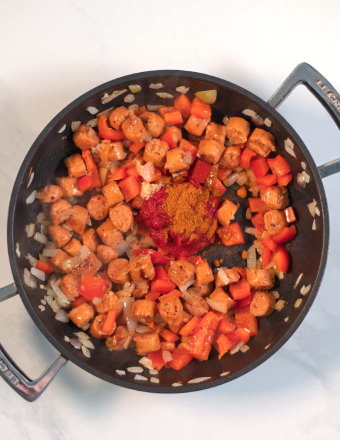 Sauce ingredients are added to the pan with the sausage.
