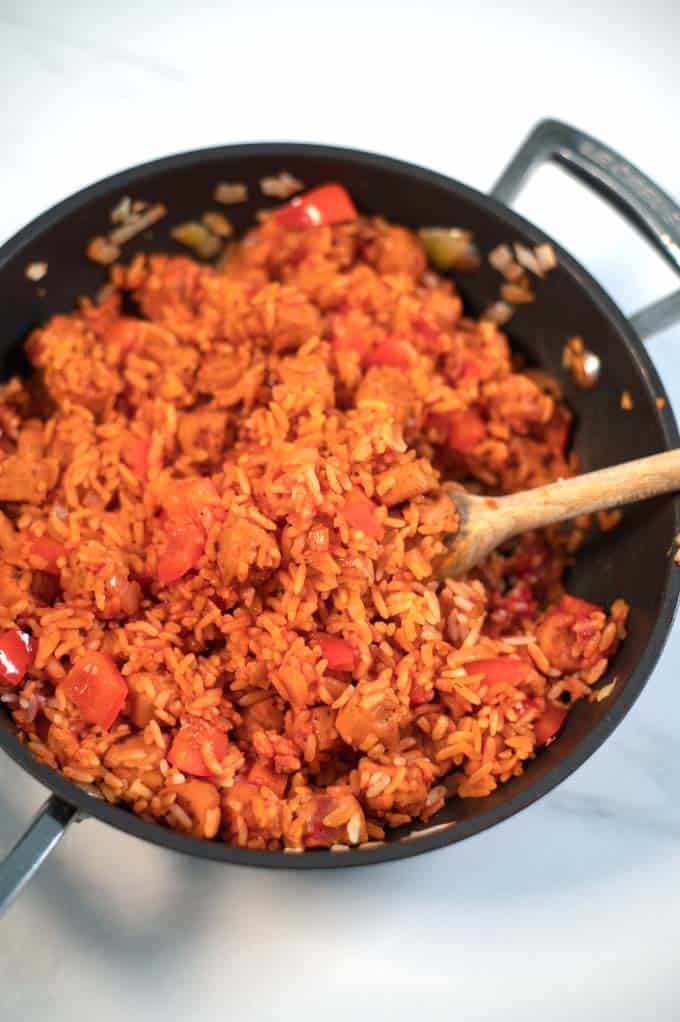 A wooden spoon in Smoked Sausage and Rice.