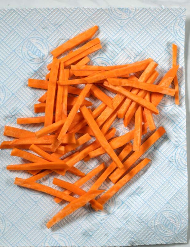 Sweet potato is dried on a paper towel.