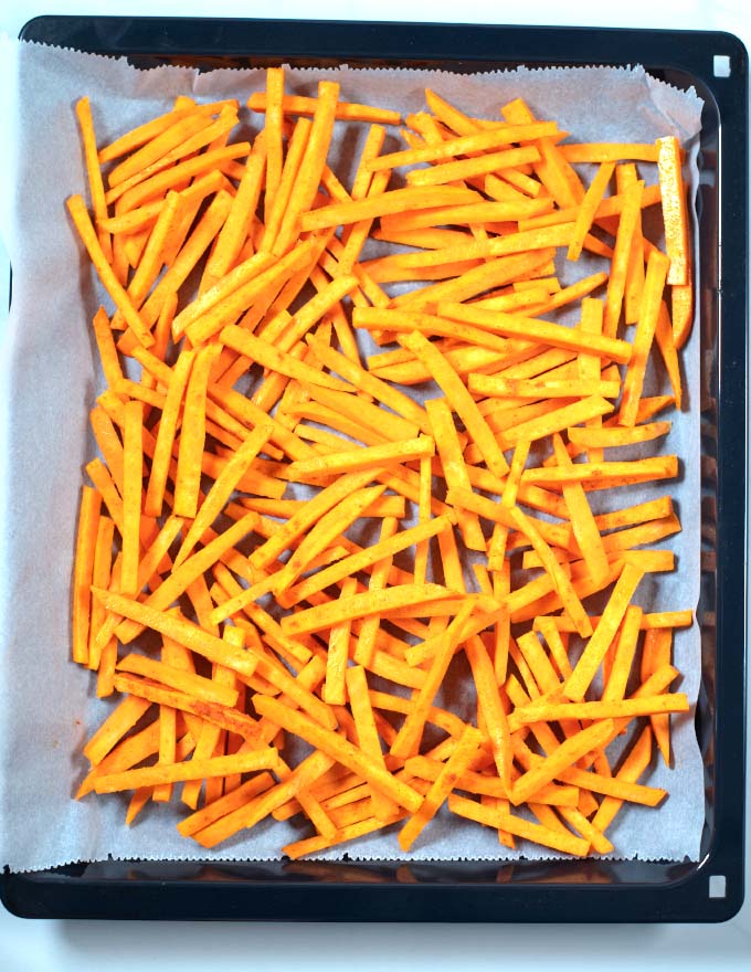Sweet potato fries on a baking sheet before baking.