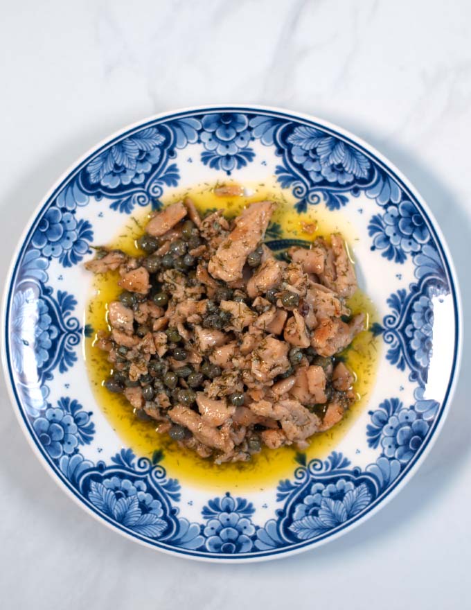 Serving of chicken with Lemon Caper Sauce on a plate.