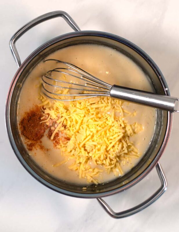 Spices, milk and vegan cheese are given into the roux base.
